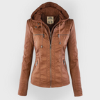 Studio shot of a women's fitted faux leather biker jacket in a warm cognac/light brown colour. The jacket has a front zipper closure, zippered chest and side pockets, detailed quilted shoulder and cuff panels, and an integrated fabric hood with drawstrings. The fit is clearly tailored and slim. Focus on the fitted silhouette and the texture of the faux leather.