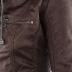 Studio shot of a women's fitted faux leather biker jacket in a warm cognac/light brown colour. The jacket has a front zipper closure, zippered chest and side pockets, detailed quilted shoulder and cuff panels, and an integrated fabric hood with drawstrings. The fit is clearly tailored and slim. Focus on the fitted silhouette and the texture of the faux leather.