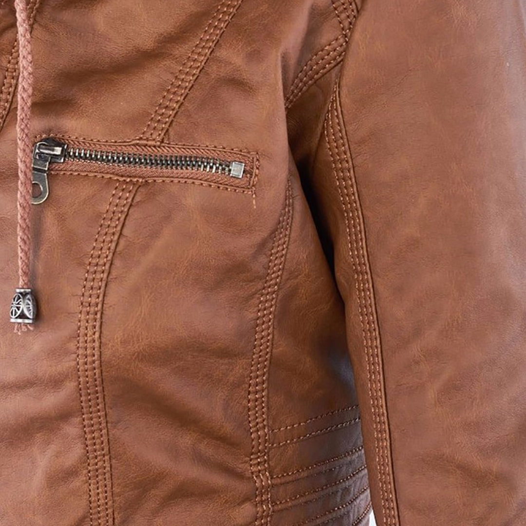 Studio shot of a women's fitted faux leather biker jacket in a warm cognac/light brown colour. The jacket has a front zipper closure, zippered chest and side pockets, detailed quilted shoulder and cuff panels, and an integrated fabric hood with drawstrings. The fit is clearly tailored and slim. Focus on the fitted silhouette and the texture of the faux leather.