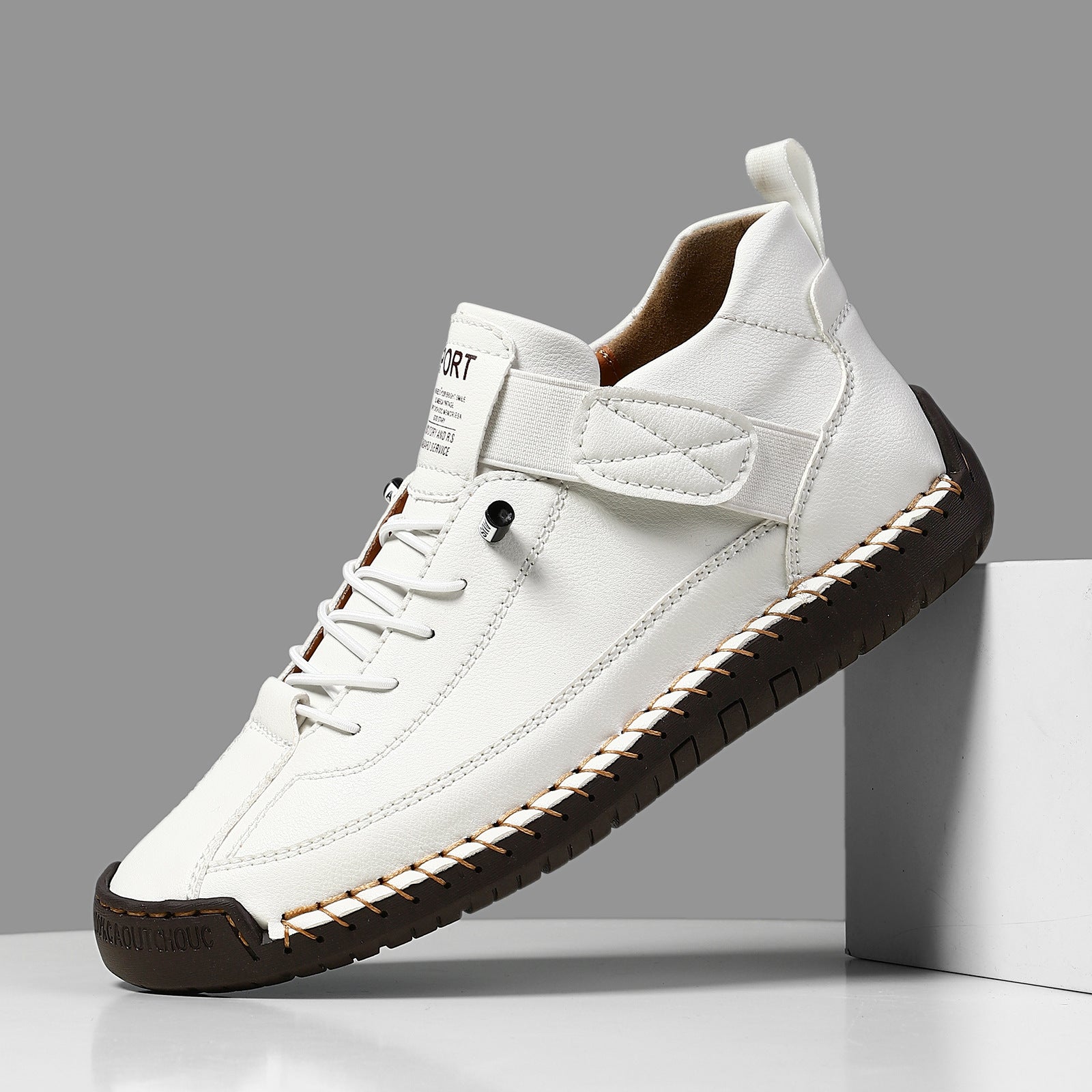 A close-up of the ALTHORA Urban Stitch Walker, a white leather casual sneaker with prominent tan moccasin-style stitching around the edges and a matching tan rubber outsole. The shoe has white laces and a small 'SPORT' label on the tongue.