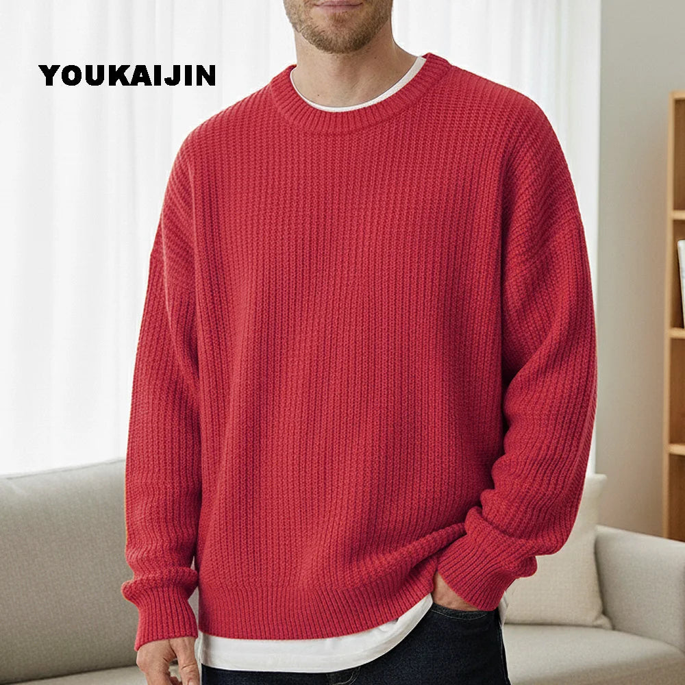 Close-up of a women's cropped, button-front sleeveless vest in a pale yellow/beige colour. The vest features a dense, chunky cable knit pattern and large brown round buttons. It is styled layered over a long-sleeve white shirt and tucked into light blue denim jeans. Focus on the rich cable texture and the cropped length.