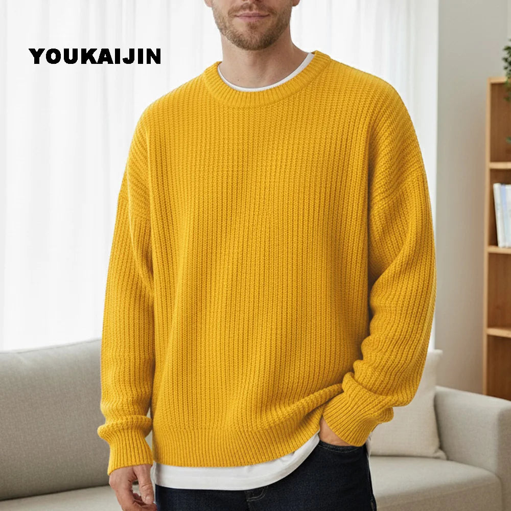 Close-up of a women's cropped, button-front sleeveless vest in a pale yellow/beige colour. The vest features a dense, chunky cable knit pattern and large brown round buttons. It is styled layered over a long-sleeve white shirt and tucked into light blue denim jeans. Focus on the rich cable texture and the cropped length.