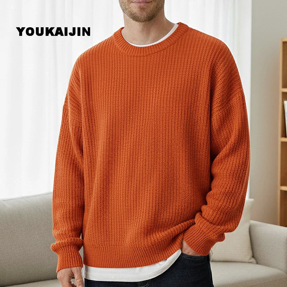 Close-up of a women's cropped, button-front sleeveless vest in a pale yellow/beige colour. The vest features a dense, chunky cable knit pattern and large brown round buttons. It is styled layered over a long-sleeve white shirt and tucked into light blue denim jeans. Focus on the rich cable texture and the cropped length.