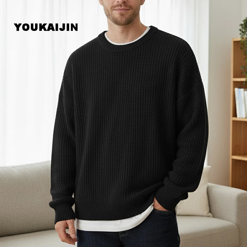 Close-up of a women's cropped, button-front sleeveless vest in a pale yellow/beige colour. The vest features a dense, chunky cable knit pattern and large brown round buttons. It is styled layered over a long-sleeve white shirt and tucked into light blue denim jeans. Focus on the rich cable texture and the cropped length.