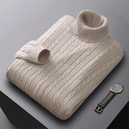 Folded men's turtleneck/roll-neck jumper in a light beige/oatmeal colour. The knit features a subtle vertical cable pattern down the body. The turtleneck and cuffs are ribbed. The sweater is styled next to a black leather men's wristwatch. Focus on the fine cable texture and the clean fold.