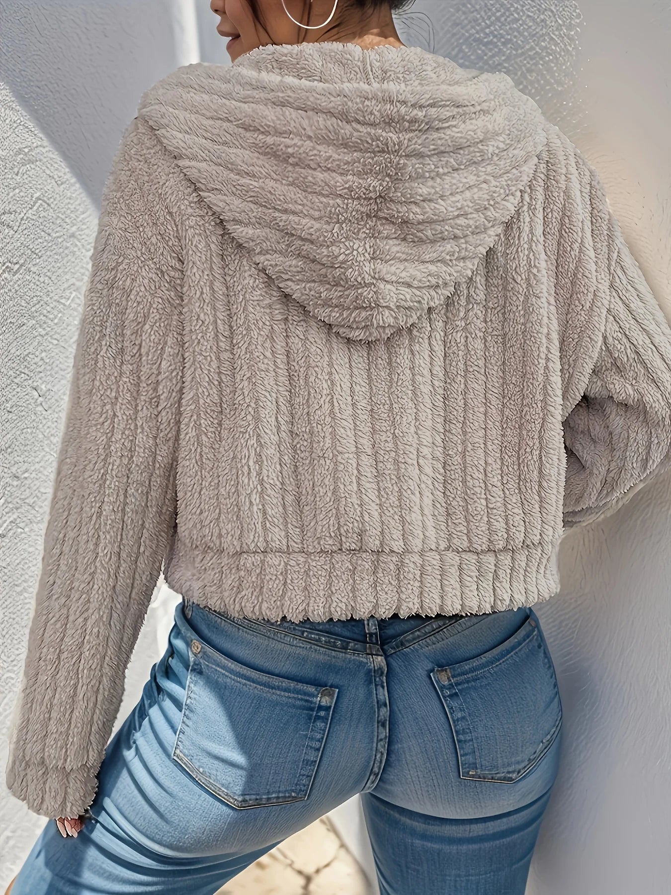 Model wearing Althora CloudSoft Zip Hoodie in beige — cropped fleece jacket with zip closure and hood.