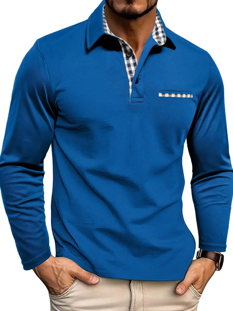 Men's long-sleeve polo shirt in a dark grey/charcoal stretch fabric with a three-button placket. The shirt features an open collar lined with blue and white gingham check fabric, and a matching gingham trim detail on the mock chest pocket. The model is standing with hands in light beige trousers pockets, showcasing the tailored fit. Focus on the contrast collar detail and the smooth texture of the fabric.