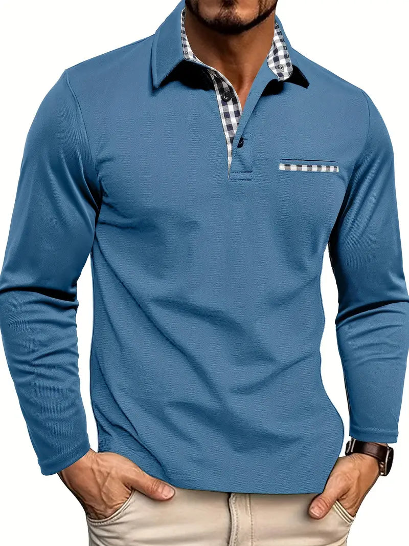 Men's long-sleeve polo shirt in a dark grey/charcoal stretch fabric with a three-button placket. The shirt features an open collar lined with blue and white gingham check fabric, and a matching gingham trim detail on the mock chest pocket. The model is standing with hands in light beige trousers pockets, showcasing the tailored fit. Focus on the contrast collar detail and the smooth texture of the fabric.